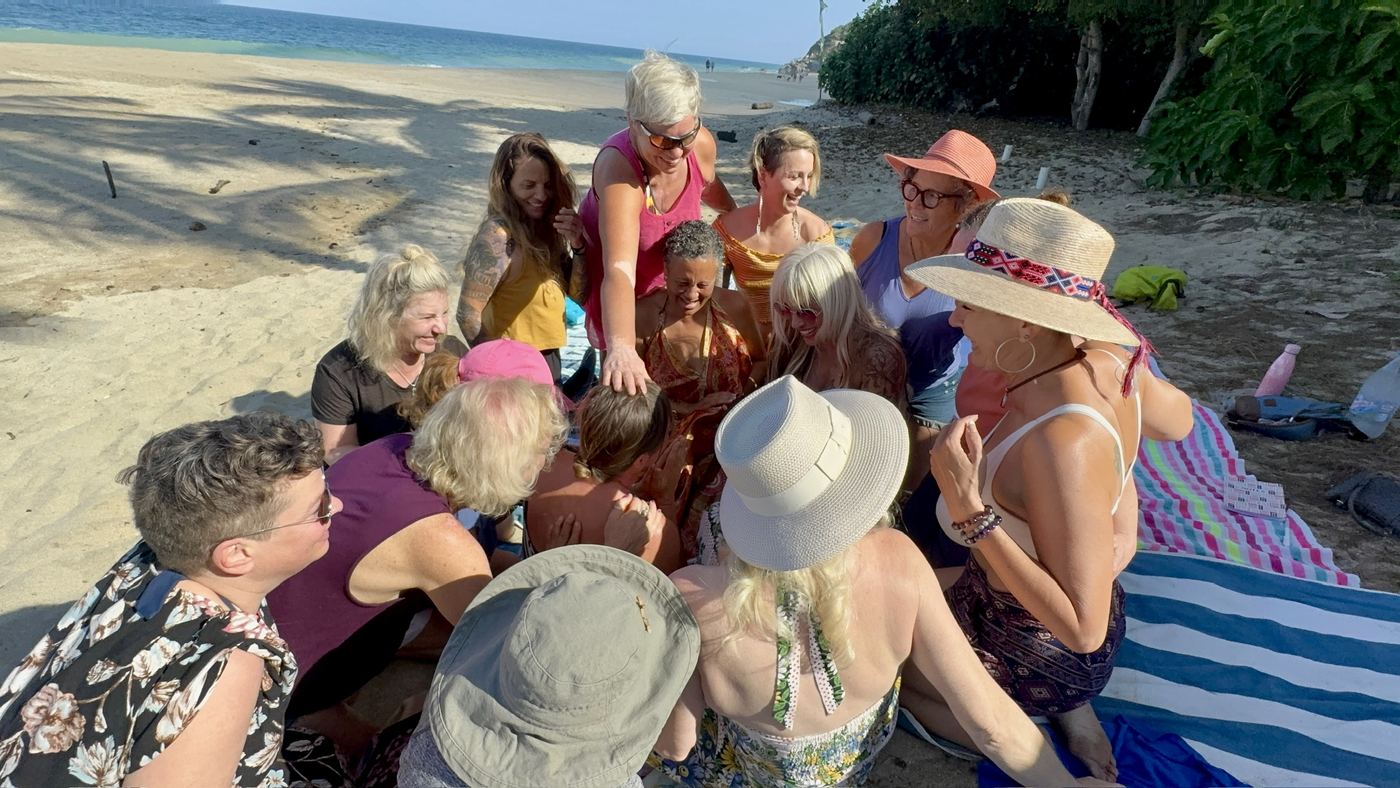 A circle of women gathered on the beach