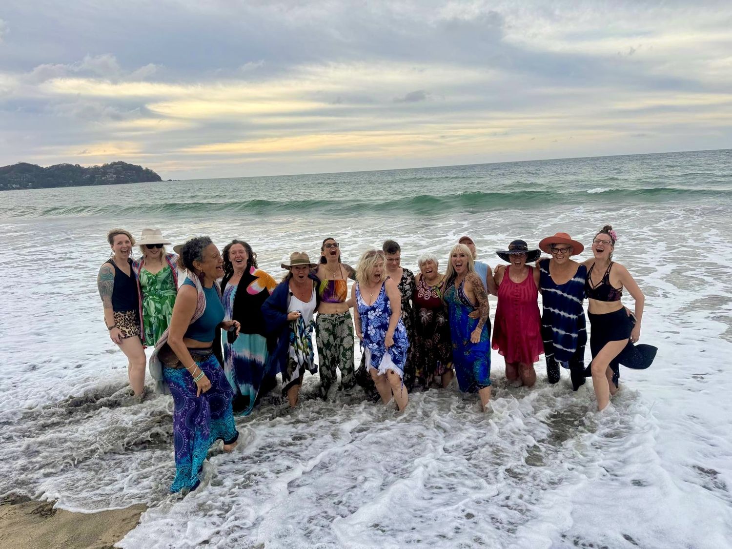 The whole circle standing in the surf at sunset