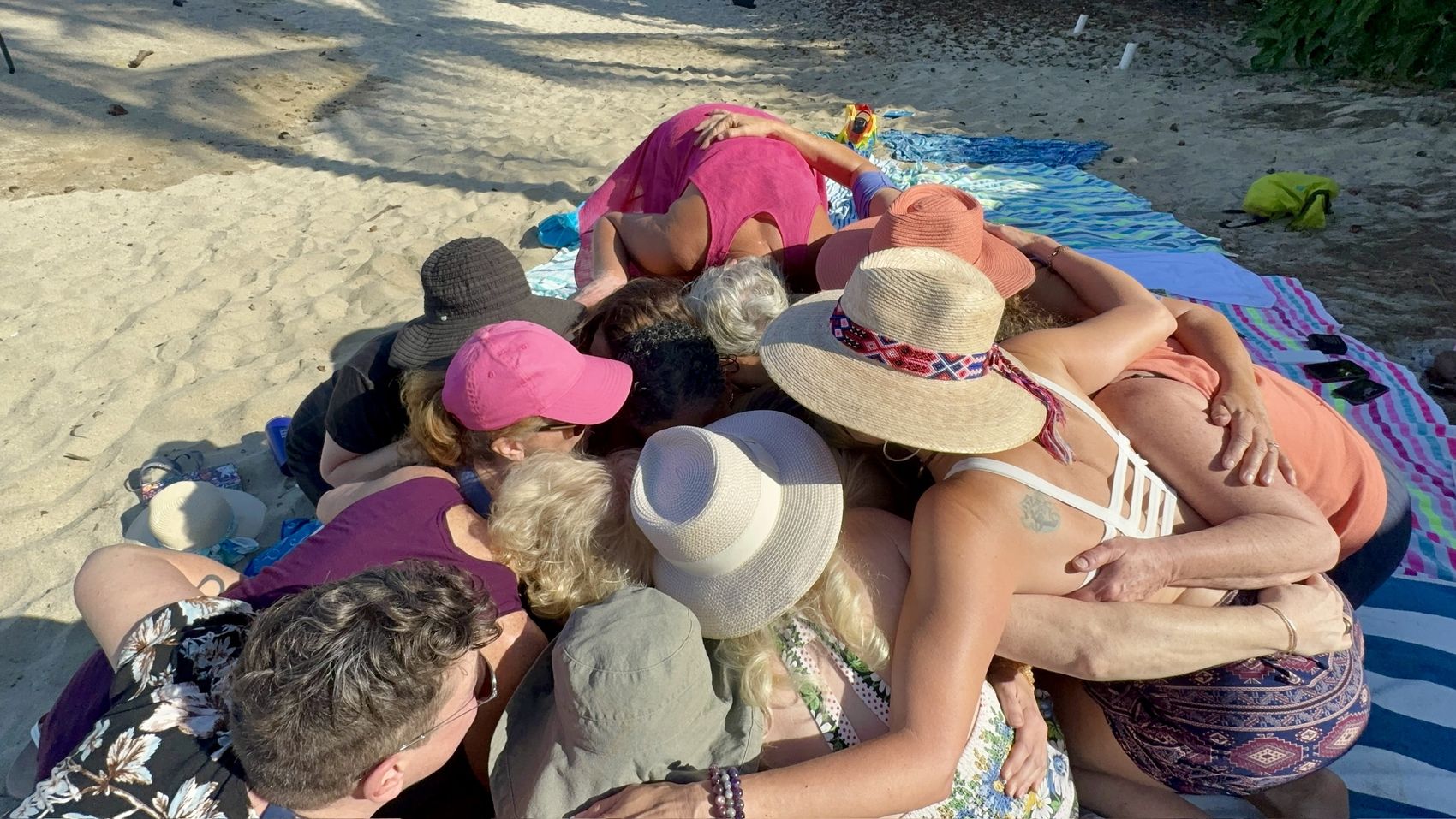 Women gathered close together on the sand