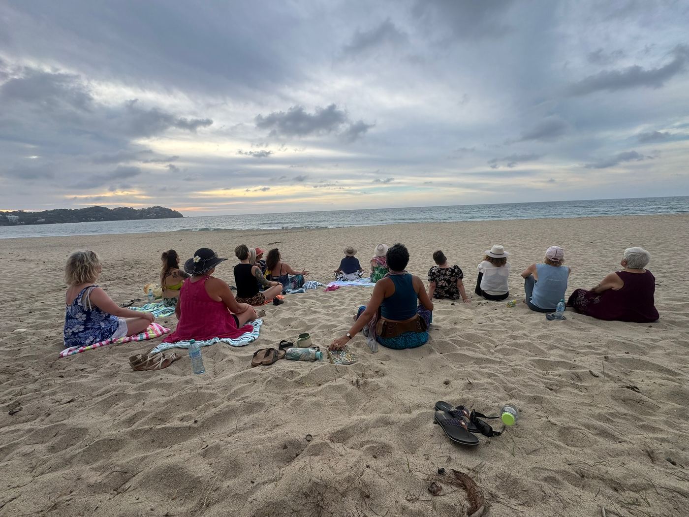 A circle seated on the sand at dusk