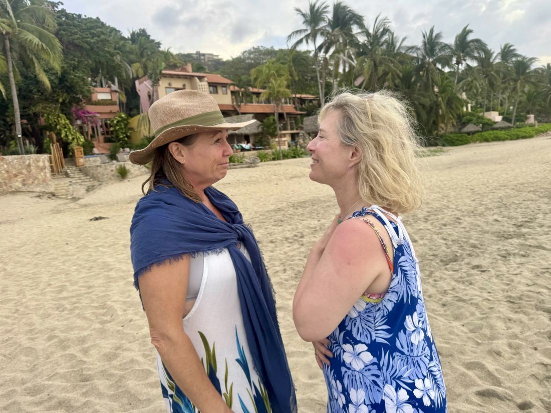 Two women in conversation on the sand